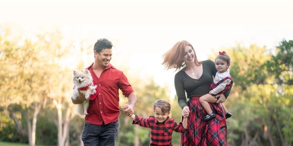 A happy family with a dog enjoying a walk outdoors.