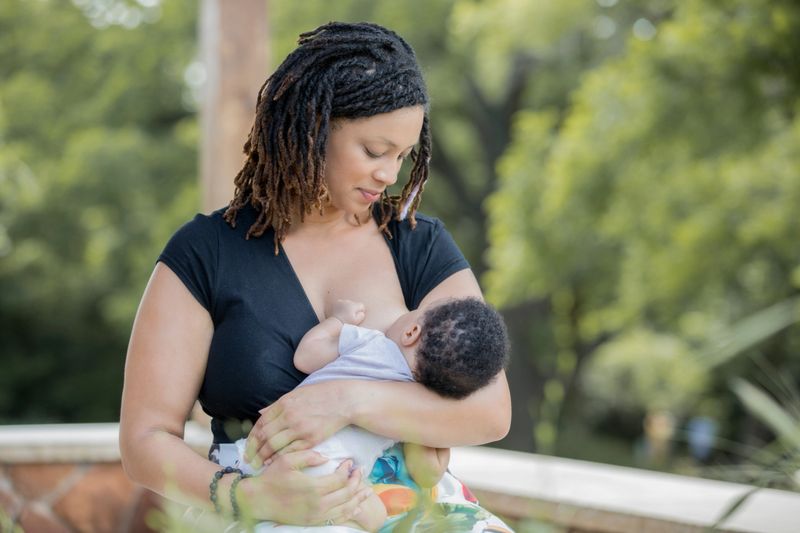 Mother nurses infant son outdoors