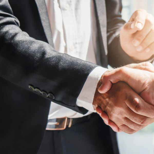 Two business professionals shaking hands in agreement.