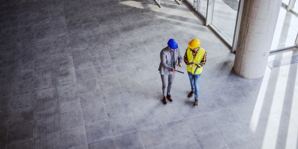Two construction professionals discussing plans indoors.