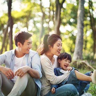 Asian parents and child playing in nature. RO DBT parent coaching. Austin and Texas.