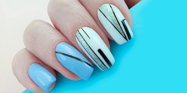 Blue and white nails with black and silver geometric designs.