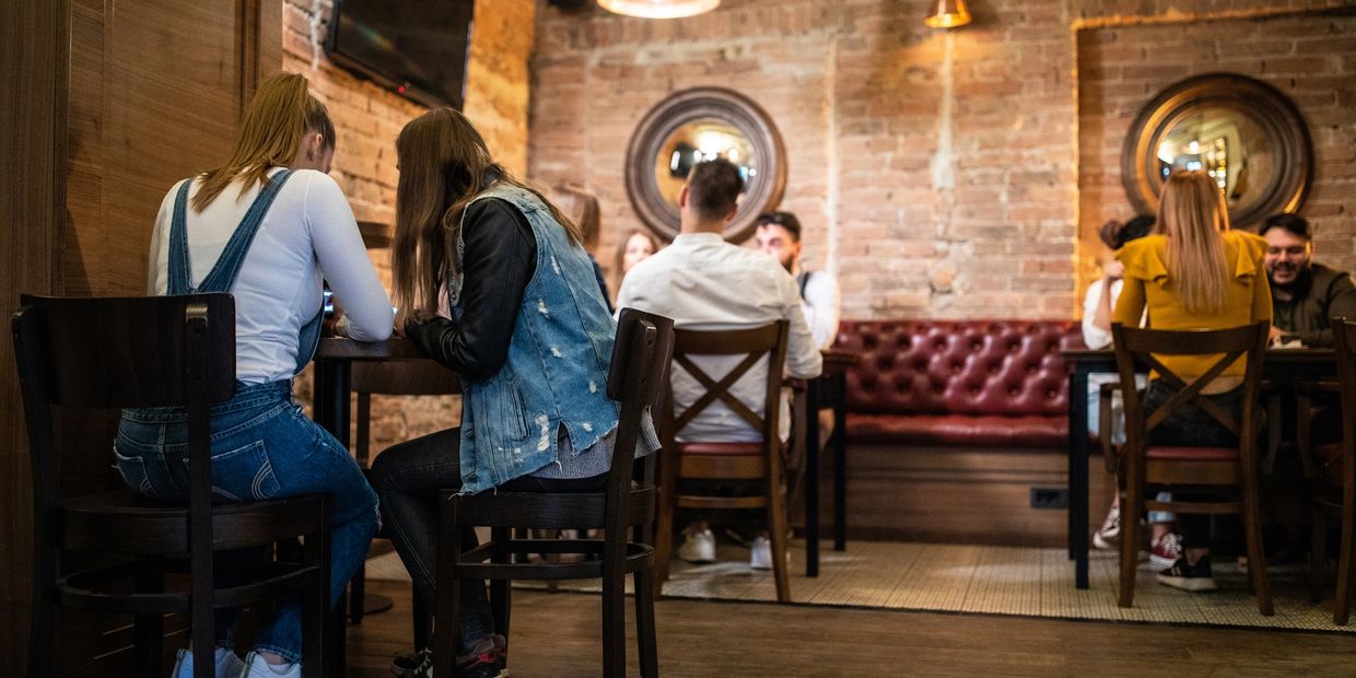 Busy Jojo Coffeehouse with rustic decor and live guitars on the wall.