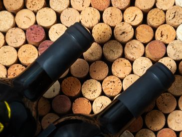 Two wine bottles on a bed of wine corks.