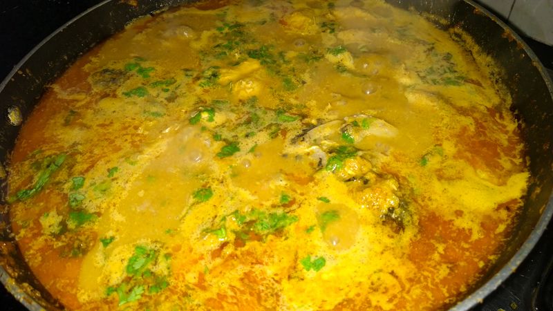 Indian style fish curry cooking in pan and served in plate with rice