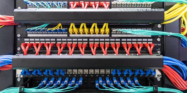 Organized network patch panel with colorful Ethernet cables connected.