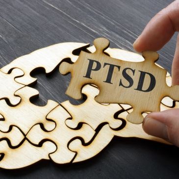 Hand placing a puzzle piece labeled PTSD.