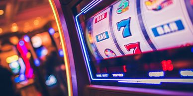 Close-up of a slot machine showing a winning combination of sevens and BAR symbols.