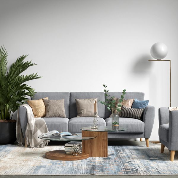 Modern living room with gray sofa, wooden coffee tables, and decorative cushions.