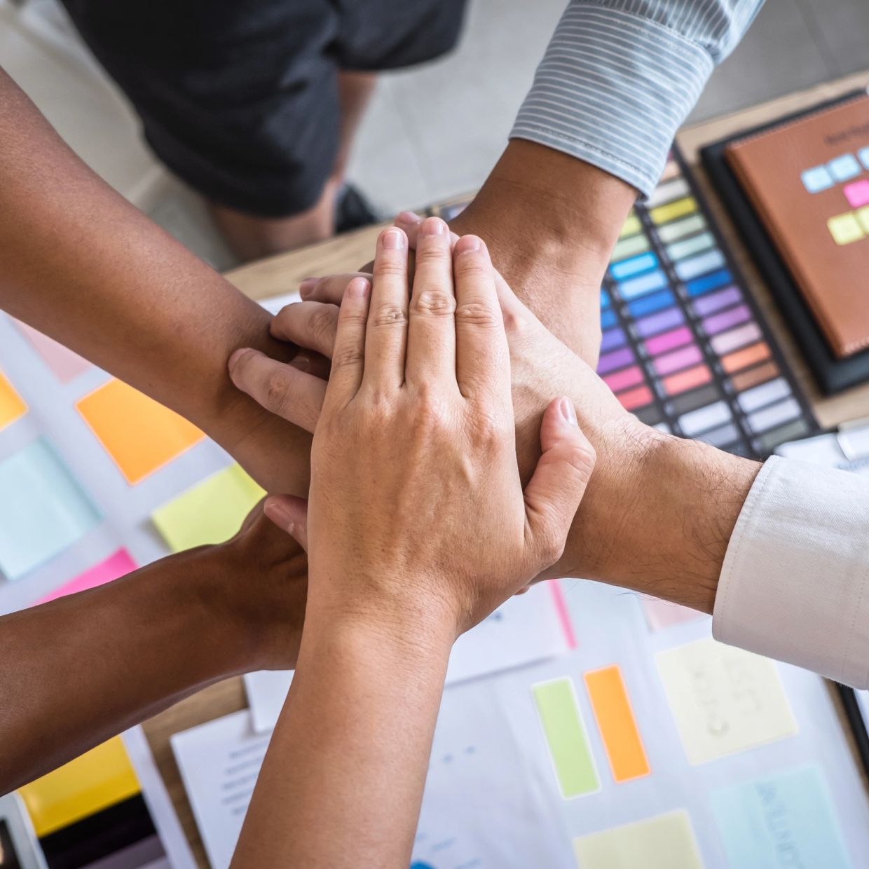 Teamwork symbolized by hands stacked together.
