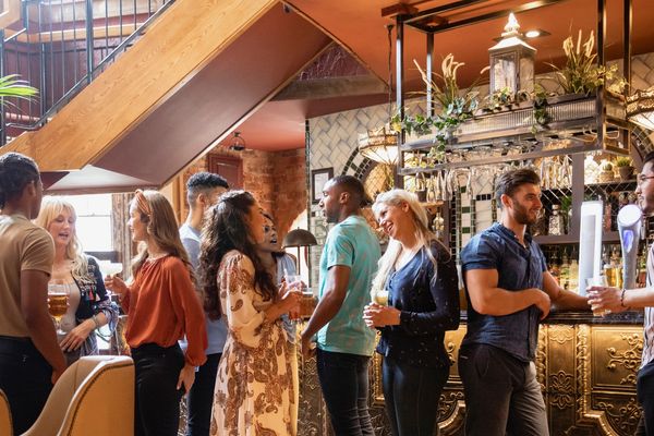 People chatting and enjoying drinks in a cozy bar.