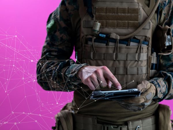 Soldier in tactical gear using a tablet with digital network connections on purple background.