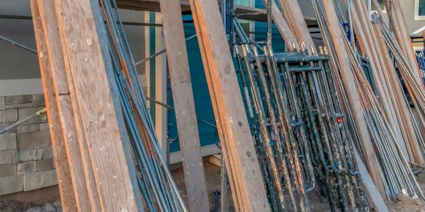 Construction materials and scaffolding leaning against a building under construction.