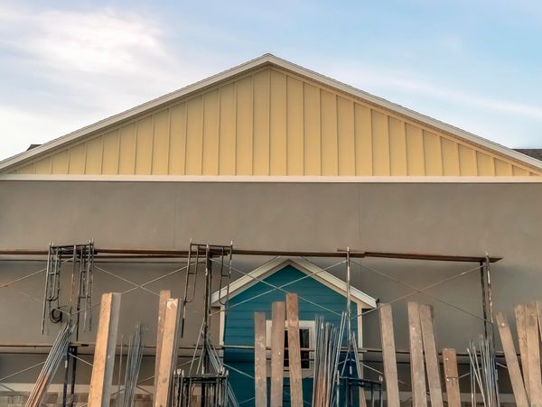 Construction scaffolding in front of a house facade under renovation.