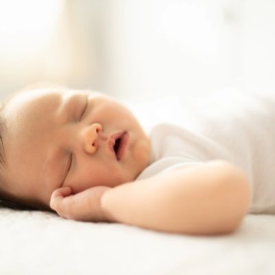 Peaceful baby sleeping soundly on a soft surface.