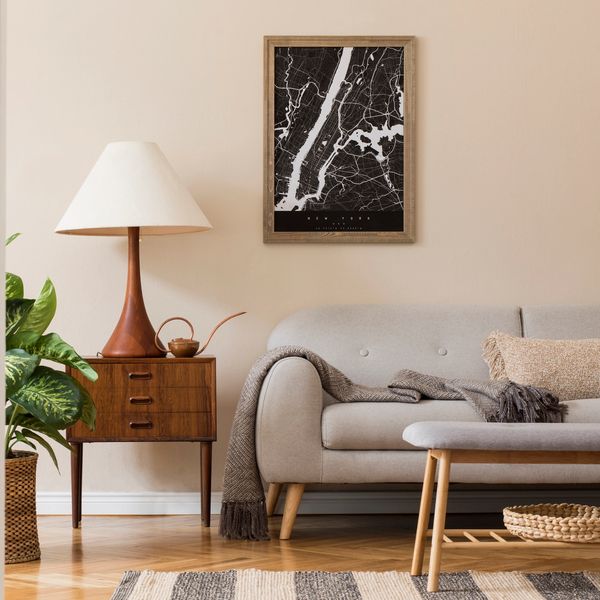 Mid-century sofa, wood side table with drawers, lamp and black & white abstract art in a gold frame.
