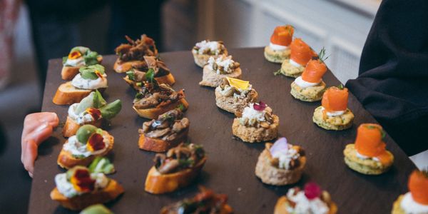 Assorted gourmet appetizers served on a wooden tray.