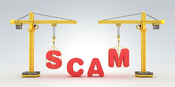 Two yellow cranes lifting red letters forming the word 'SCAM'.
