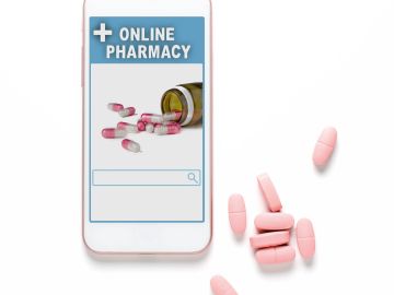 Online pharmacy concept with pills and smartphone.