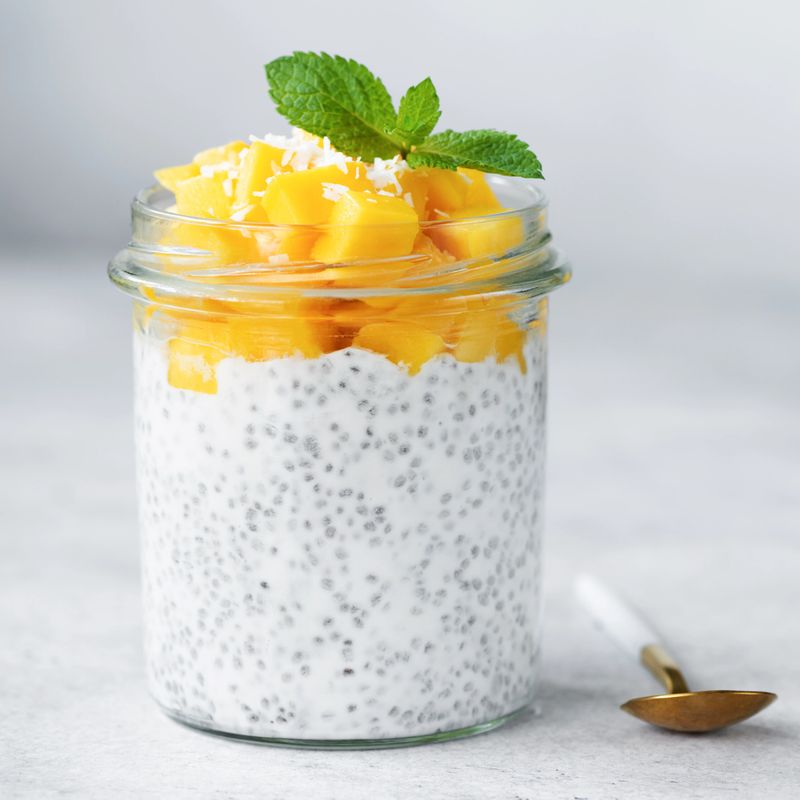 Chia seed pudding with mango in glass jar. Square composition. Clean eating, healthy vegan vegetarian food concept