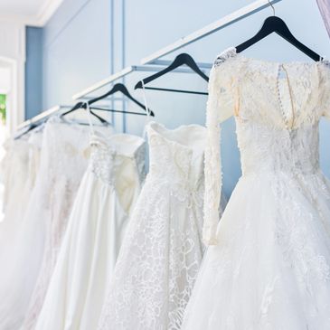 A row of elegant white wedding dresses hanging on a rack.
