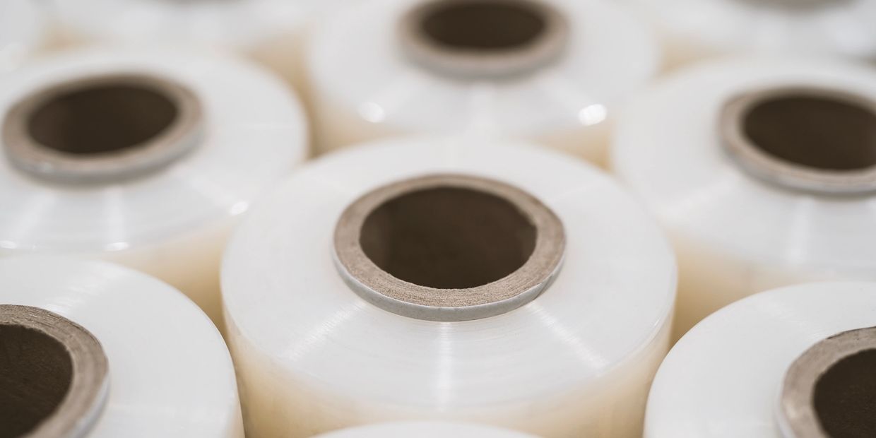 Close-up of multiple rolls of clear plastic wrap with cardboard cores.