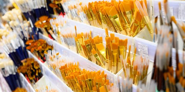 Rows of various paintbrushes organized in containers.
