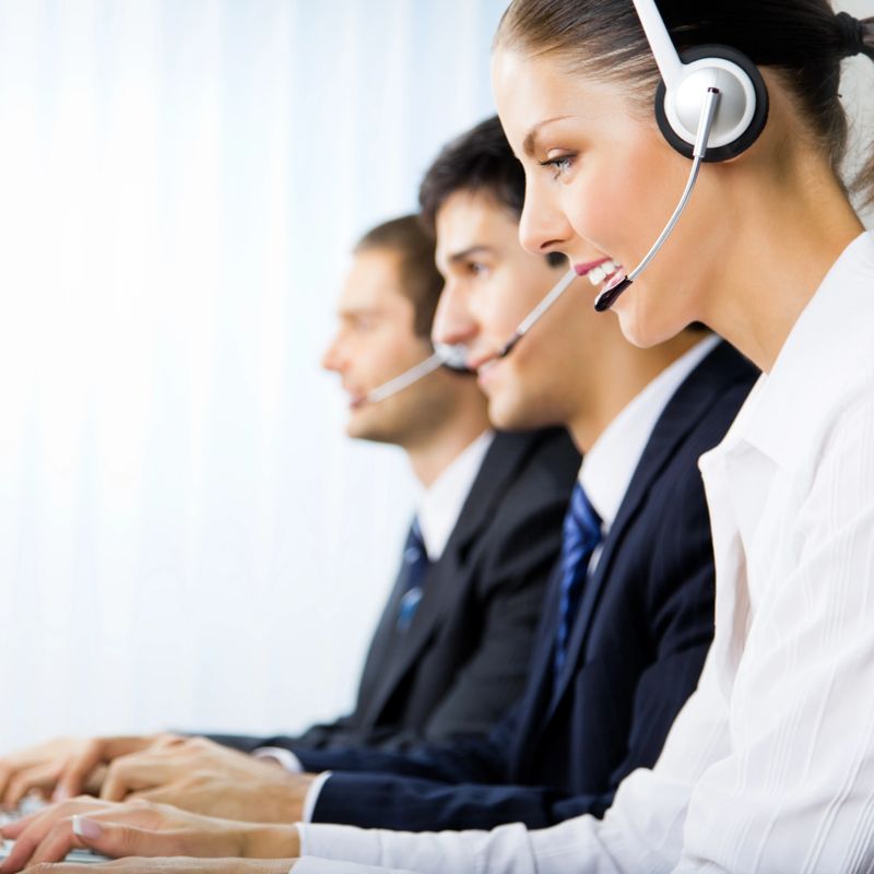 Three support phone operators at workplace