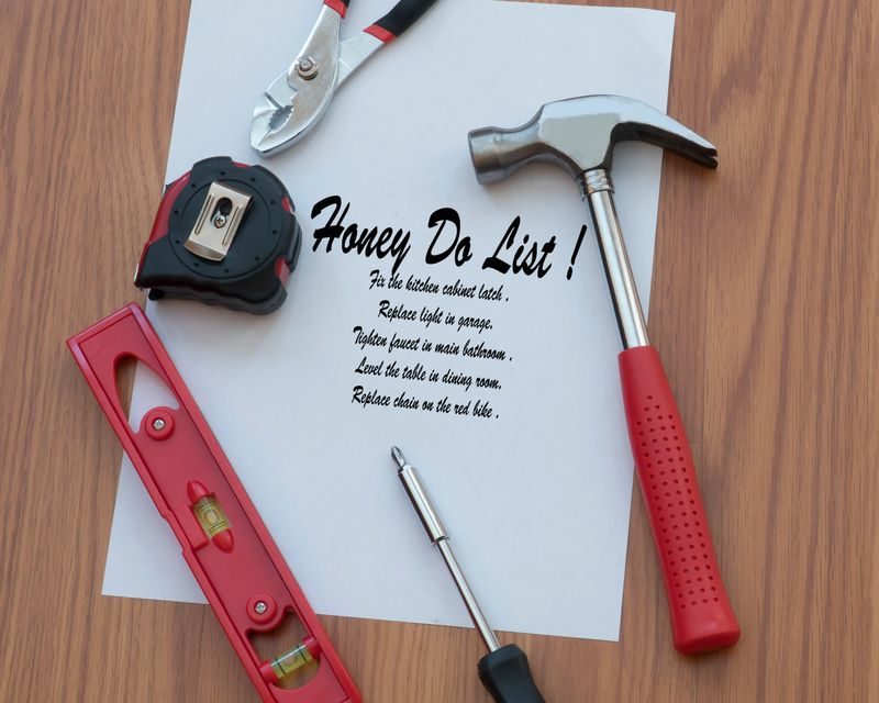 Various tools surround the DIY honey do list that need work or repair in a home.
