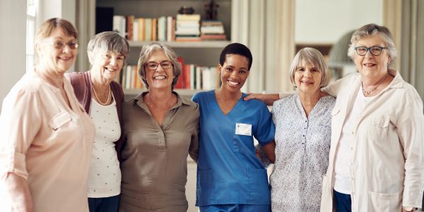 Grupo diverso de mujeres sonriendo juntas en un interior.