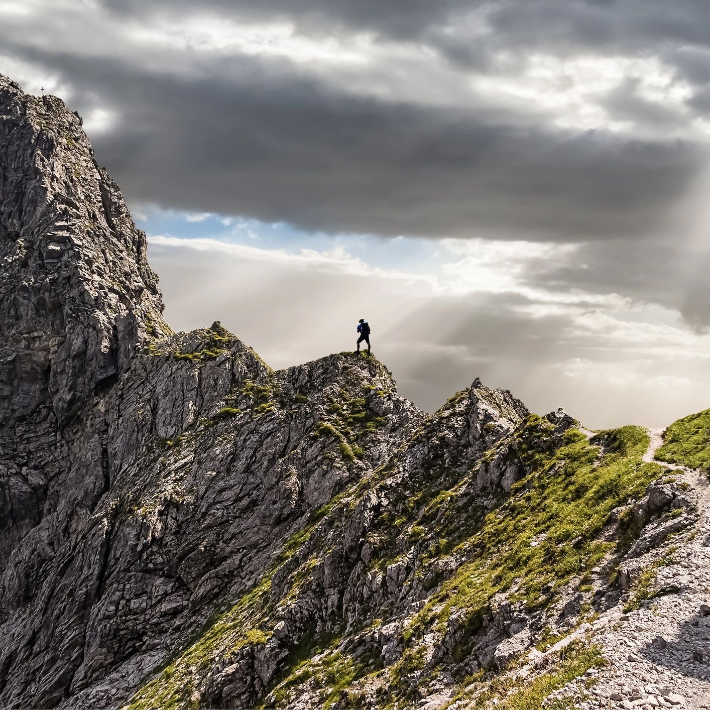 A person on a rugged mountain ridge symbolising growth and the journey of capacity-building.