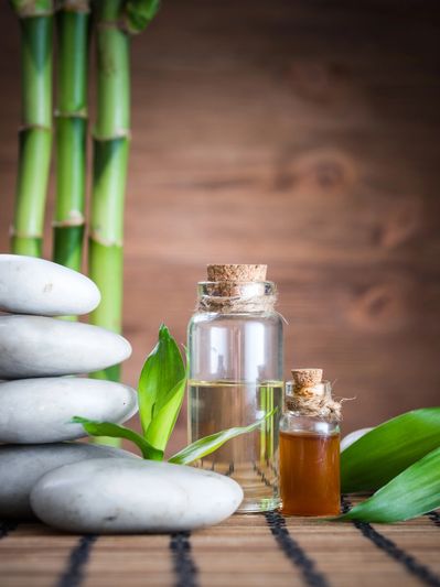 Stacked white stones, bamboo, and essential oils for spa relaxation.