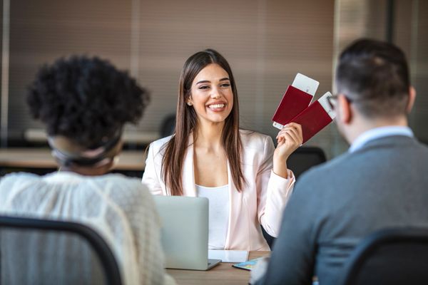 Travel agent showing passports and tickets to clients.