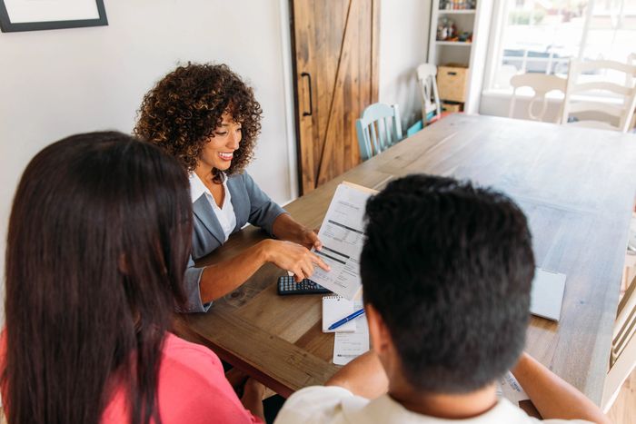 Stack of books next to pencils in a holder and a camera.