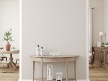Minimalist wooden console table with decorative vases and candles in a bright living space.