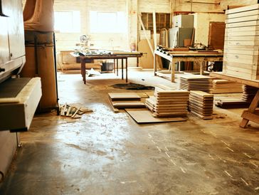 A woodworking shop with stacked wood and tools.