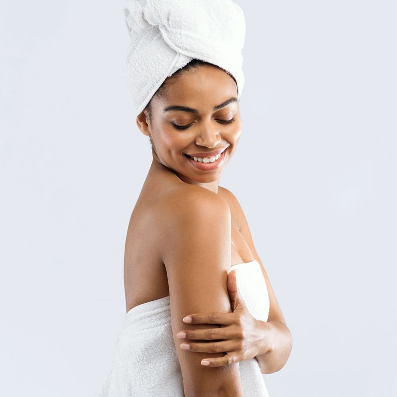 Portrait of cheerful afro girl enjoying her silky skin after spa procedures