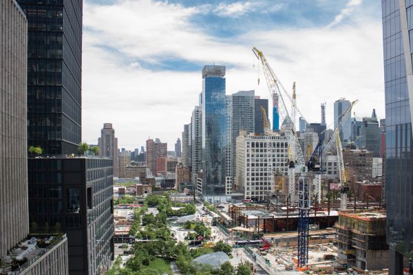 Cityscape with construction cranes and modern buildings.