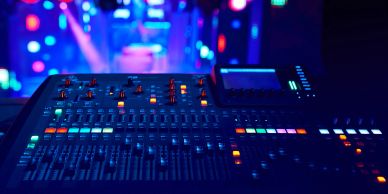 Audio mixing console with colorful lights.