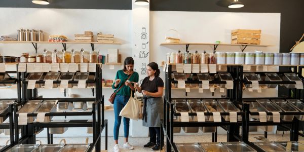 Two women talking in a bulk food store.