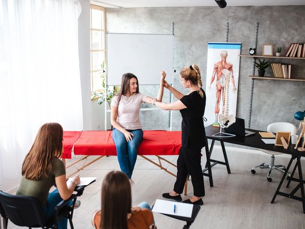 Female massage/acupuncture therapist learning student everything about massage, human body
