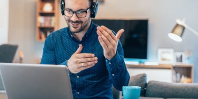 Man with headphones engaging in a video call at home.