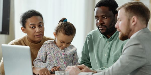 Famille noire accompagnée lors d’une consultation financière gratuite avec Taxeclair.
