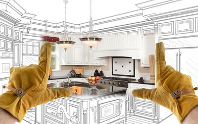 Hands in gloves framing a modern kitchen in a partially sketched design.
