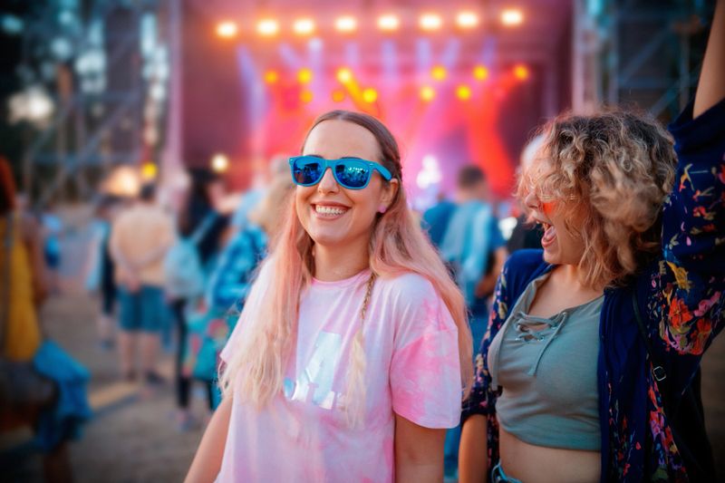 Female friends having fun while attending music festival, copy space