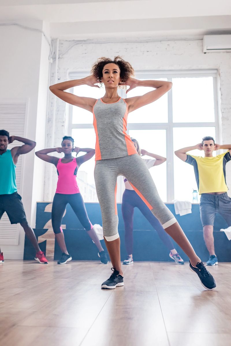 Selective focus of multiethnic zumba dancers exercising with african american trainer in dance studio
