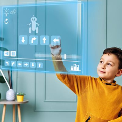A child interacts with a futuristic transparent touchscreen displaying a robot and directional arrows.