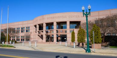 Exterior view of a government center building under clear blue sky.