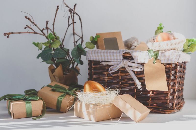 Easter zero waste, environmentally friendly gift wrapping kraft paper, eggs in a basket, gift basket, cozy religious Easter holiday, eco concept eco friendly decor banner on gray background