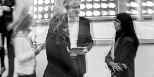 Personnes discutant dans un cadre flou en noir et blanc.